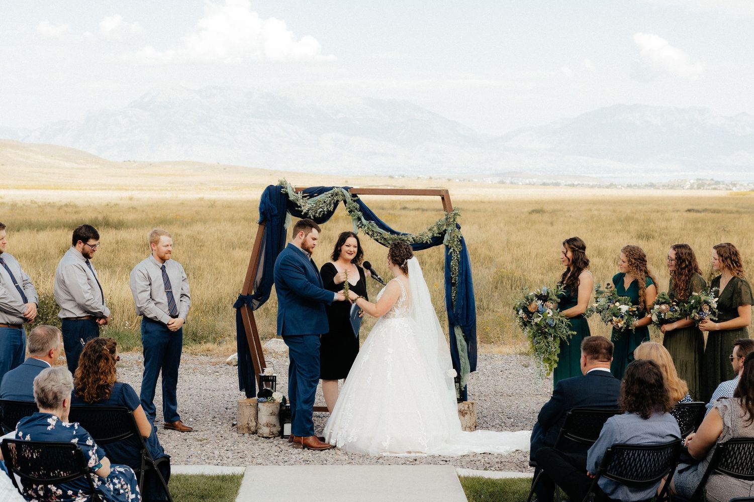 Love Stories Officiant marries smiling couple in Utah meadow surrounded by friends and family