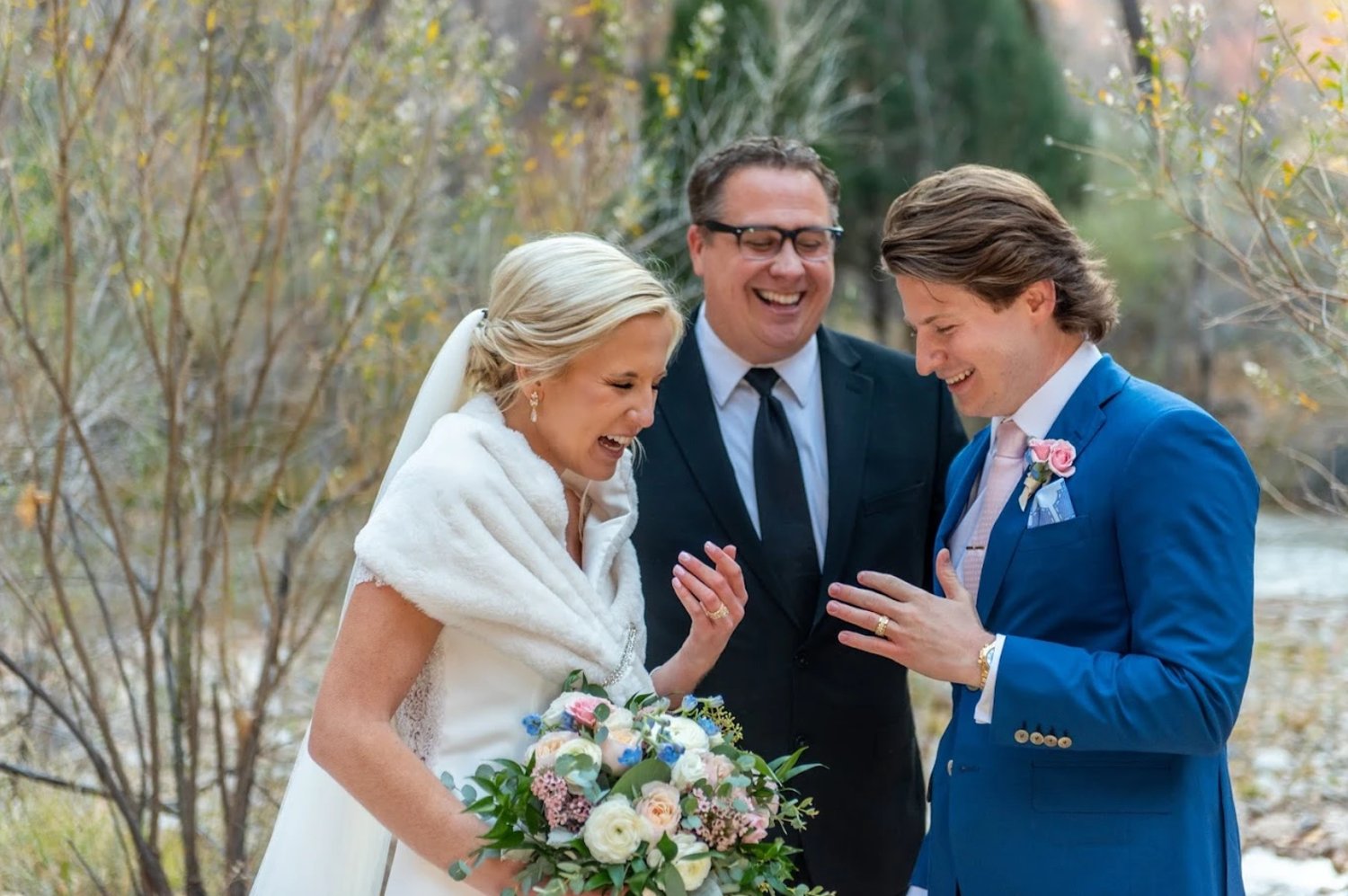 mike foley laughing with a bride and groom in zions national park as he officiates their wedding