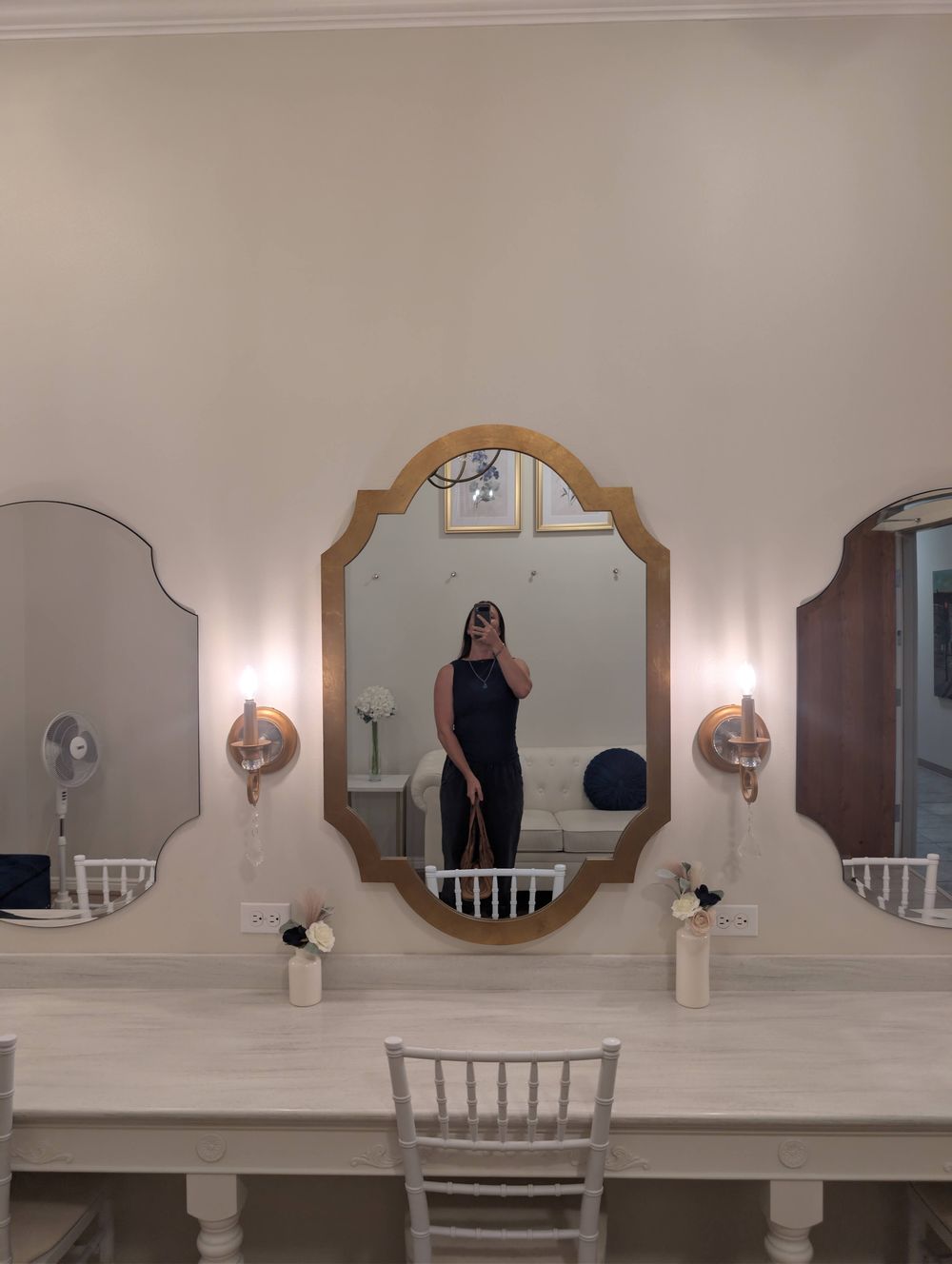 Bride's room triple vanity mirror station with gold sconces and fresh flower bud vases