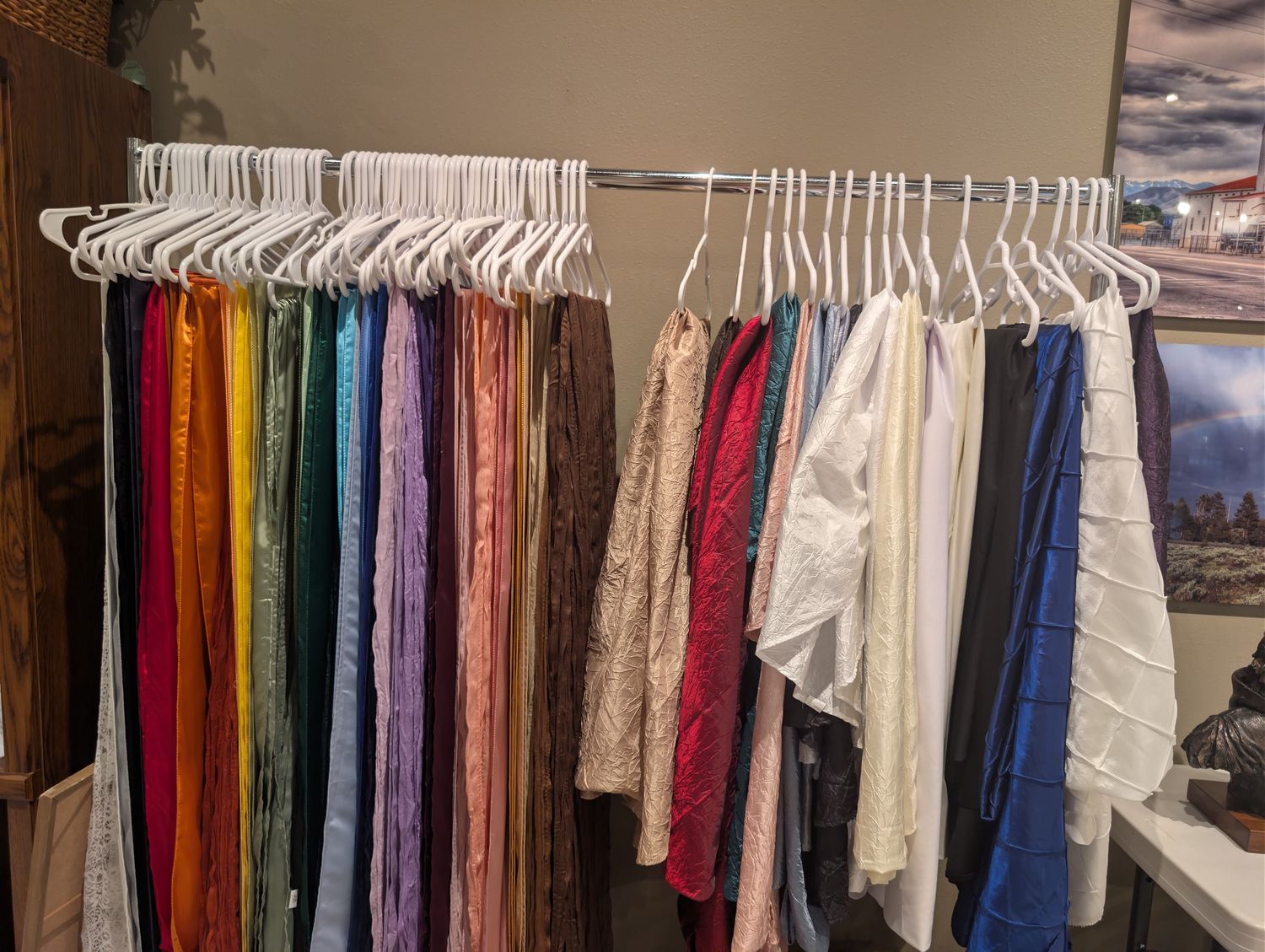 Rack of colorful linen samples, tablecloths and table runners in dozens of colors and fabrics, available for couples to choose from