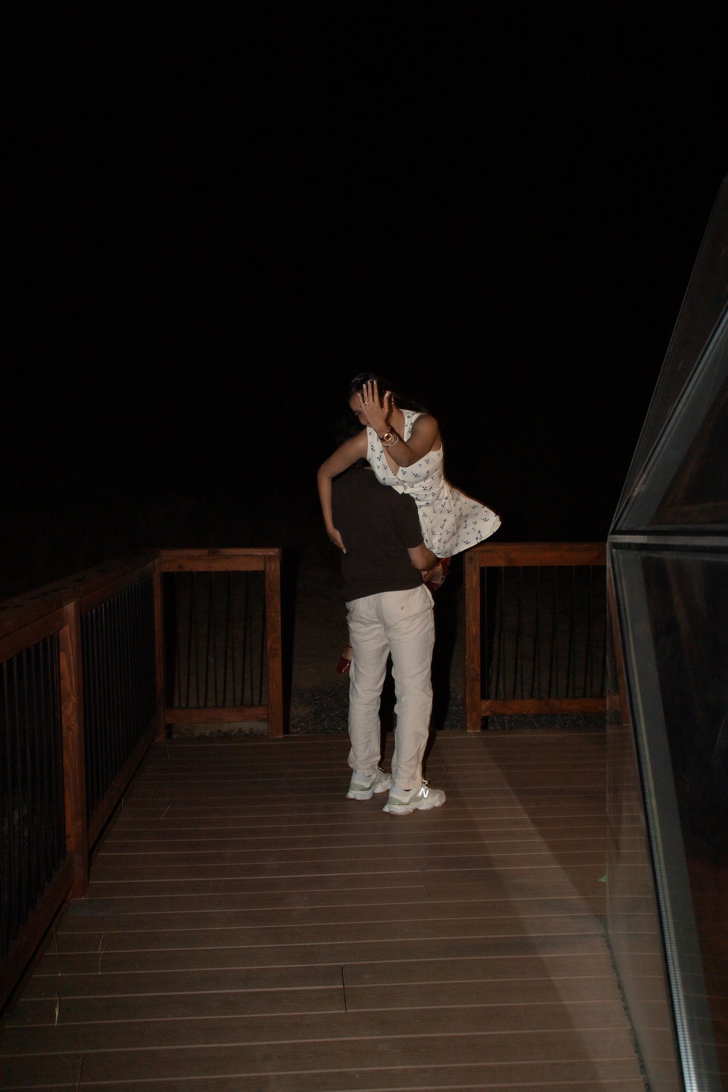 Couple sharing an embrace on a deck at night just after a surprise proposal near Bryce Canyon