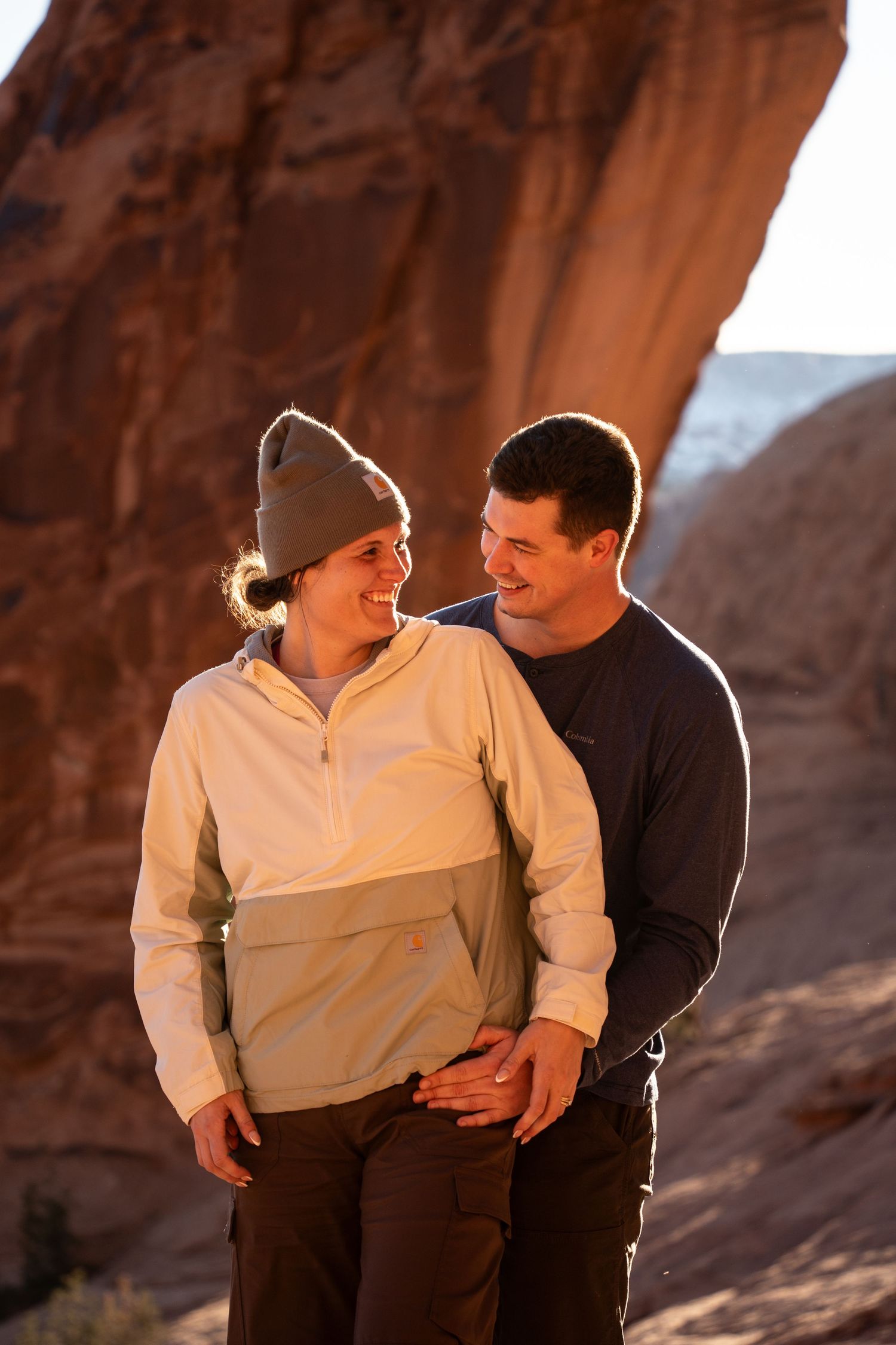 Couple smiling at each other in front of red rock scenery
