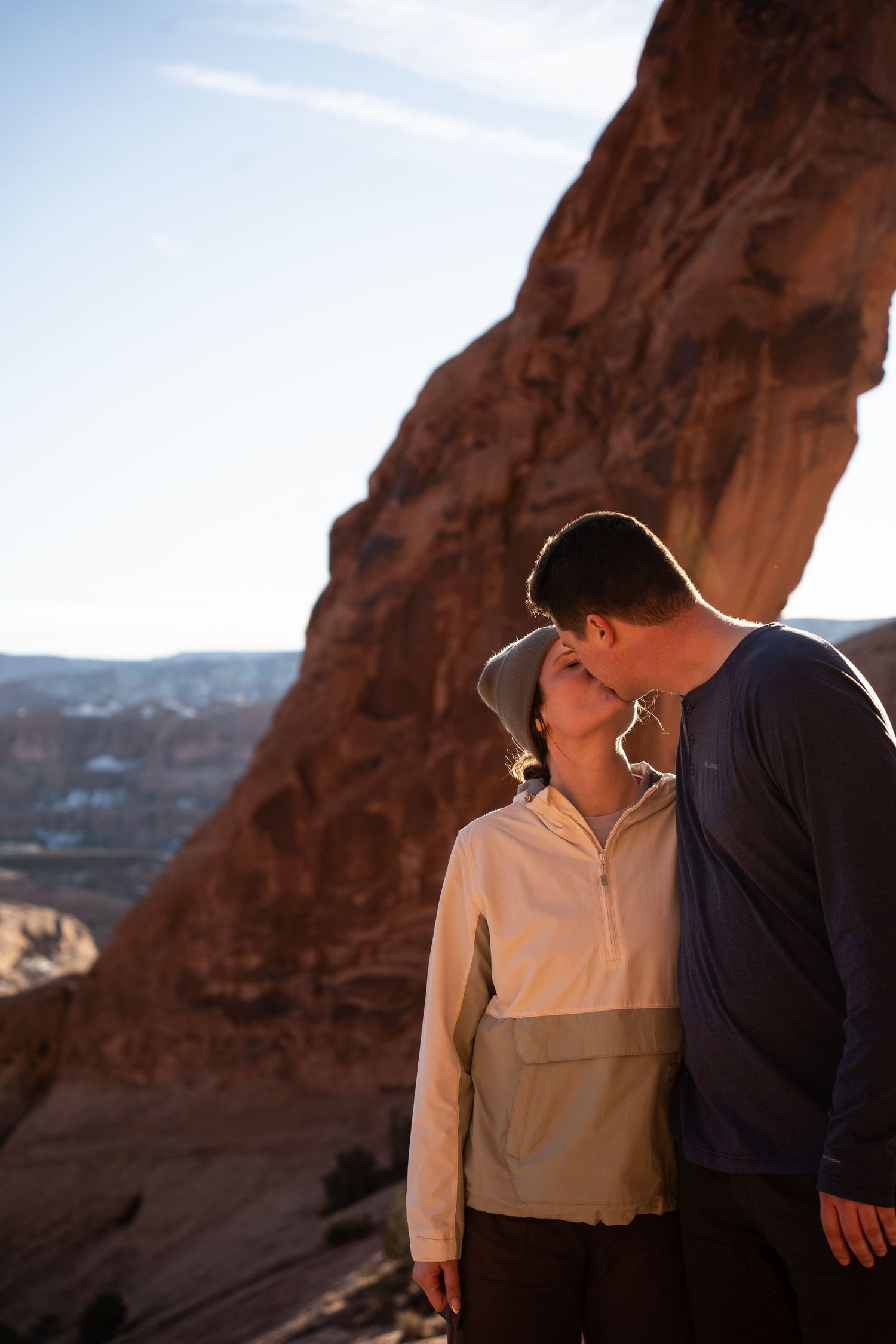 Couple sharing a romantic kiss against red rock canyon walls