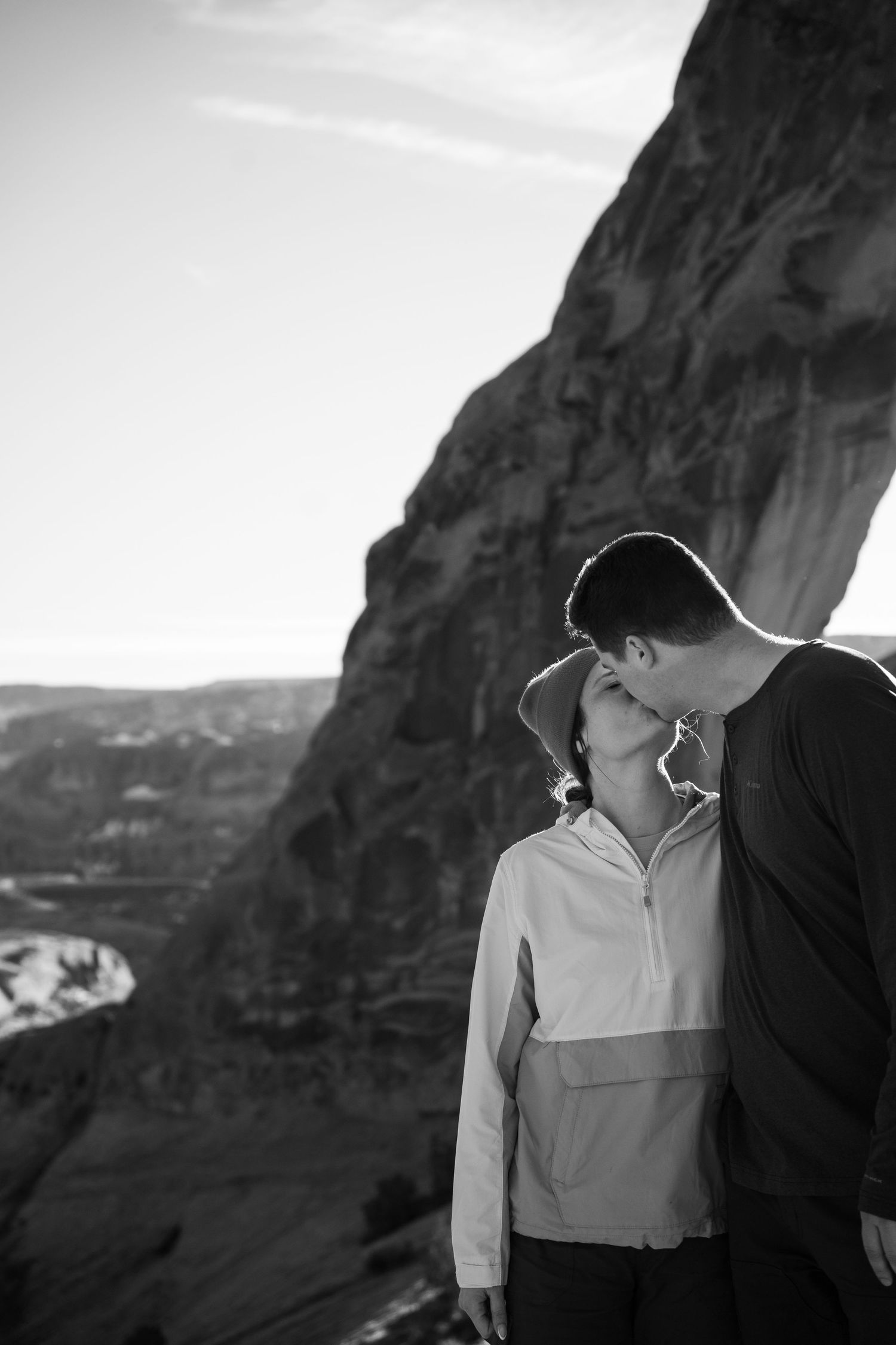 Black and white photo of a newly engaged couple kissing