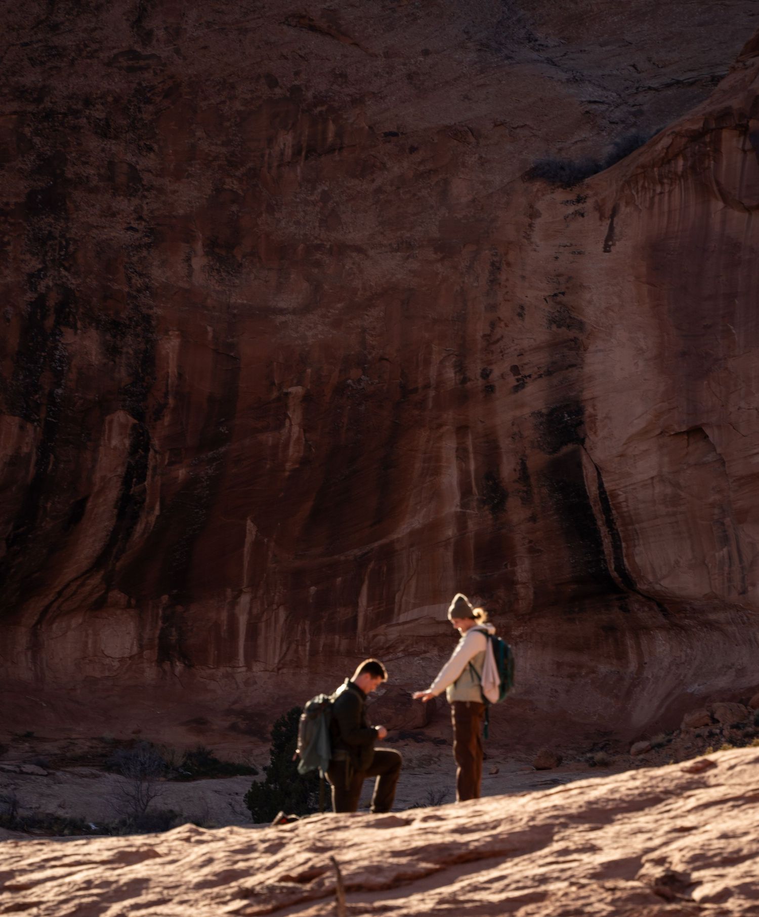 Proposal at the base of a towering red sandstone canyon wall