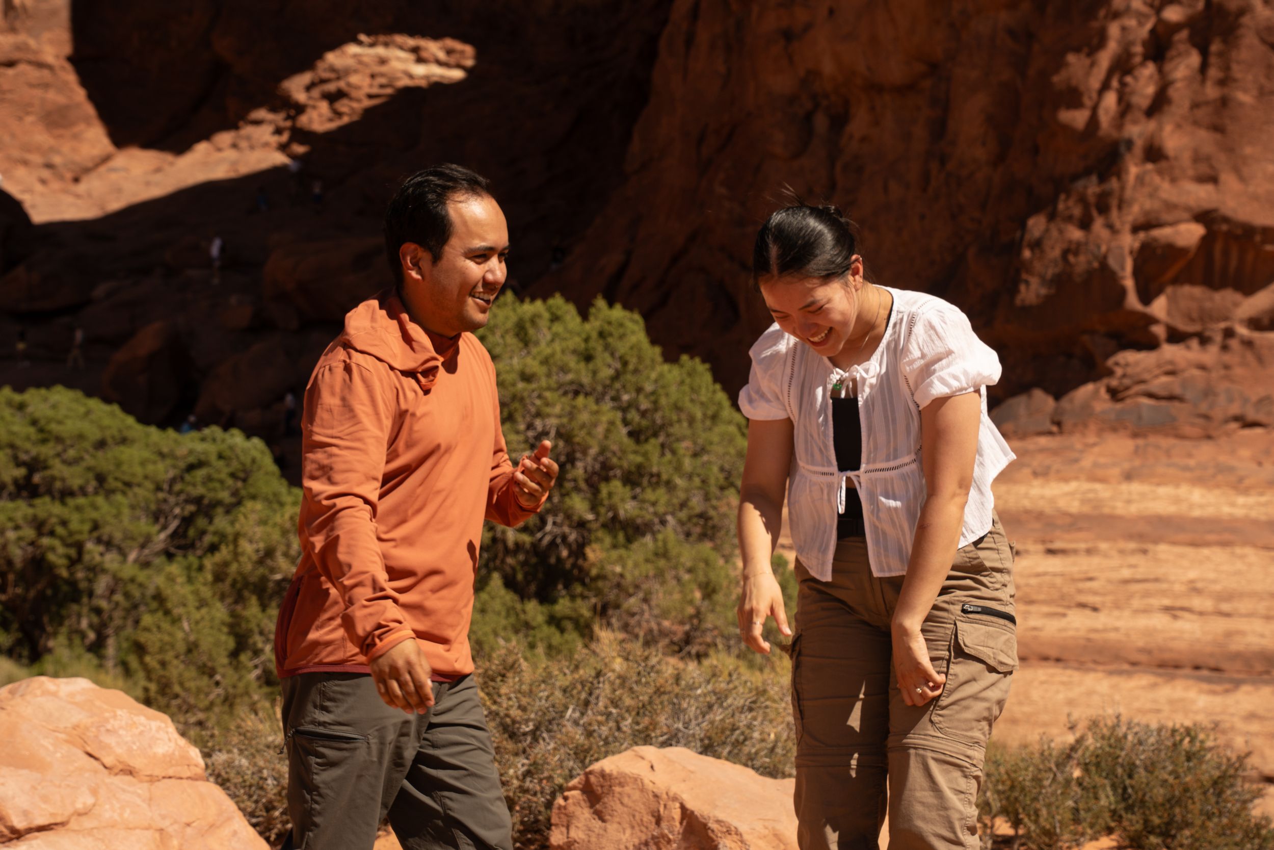 man and woman exclaiming after surprise hiking proposal in arches national park