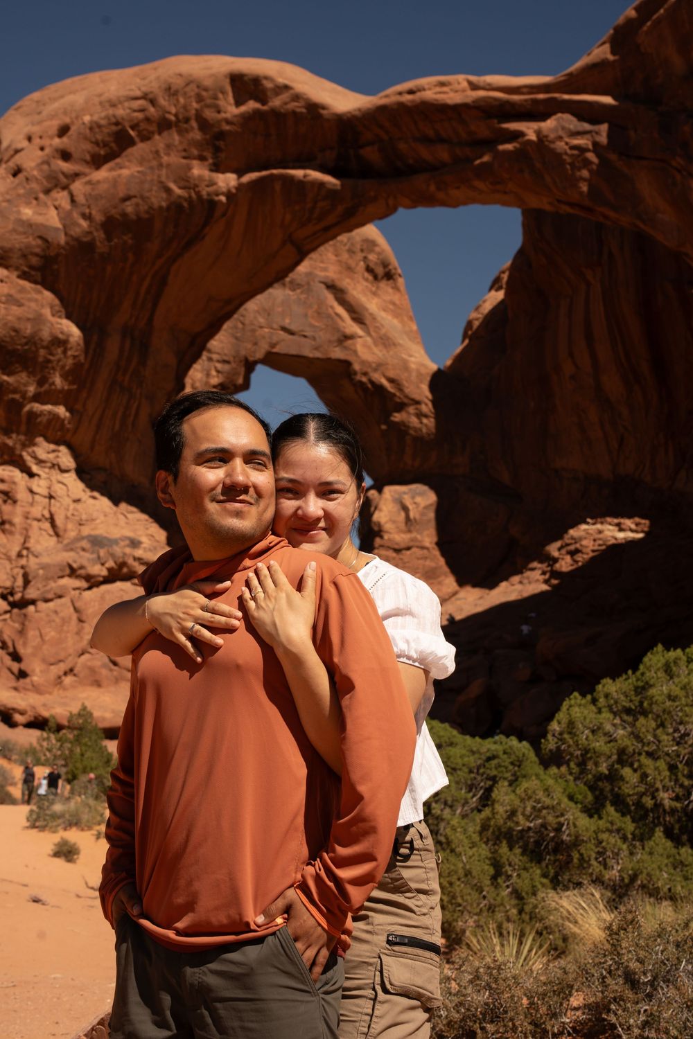 Couple walking together on a red rock trail in Arches National Park, Utah