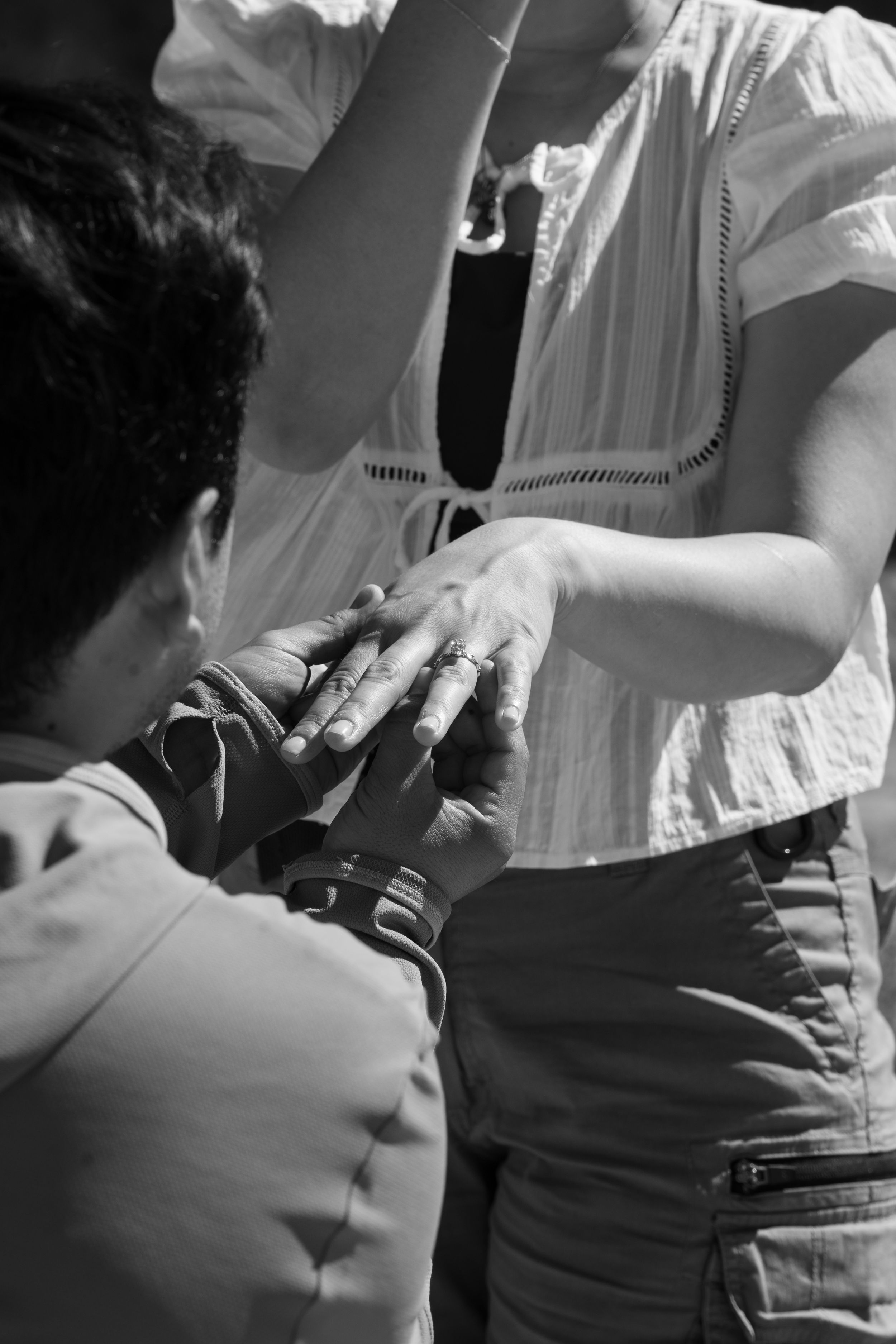 Black and white photo of man proposing to his girlfriend with a beautiful custom engagement ring
