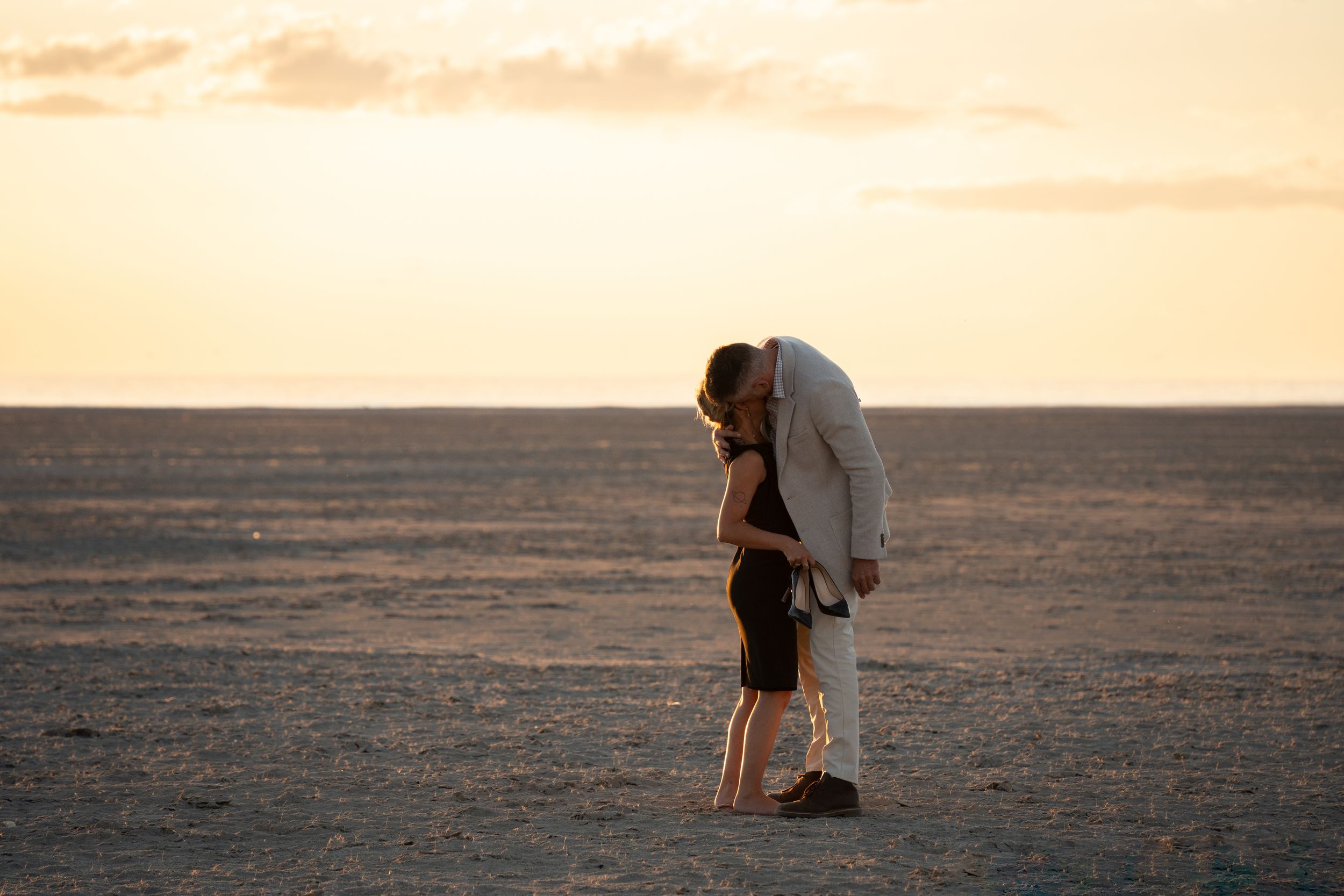 Couple embracing at sunset on the Bonneville Salt Flats after a Utah proposal