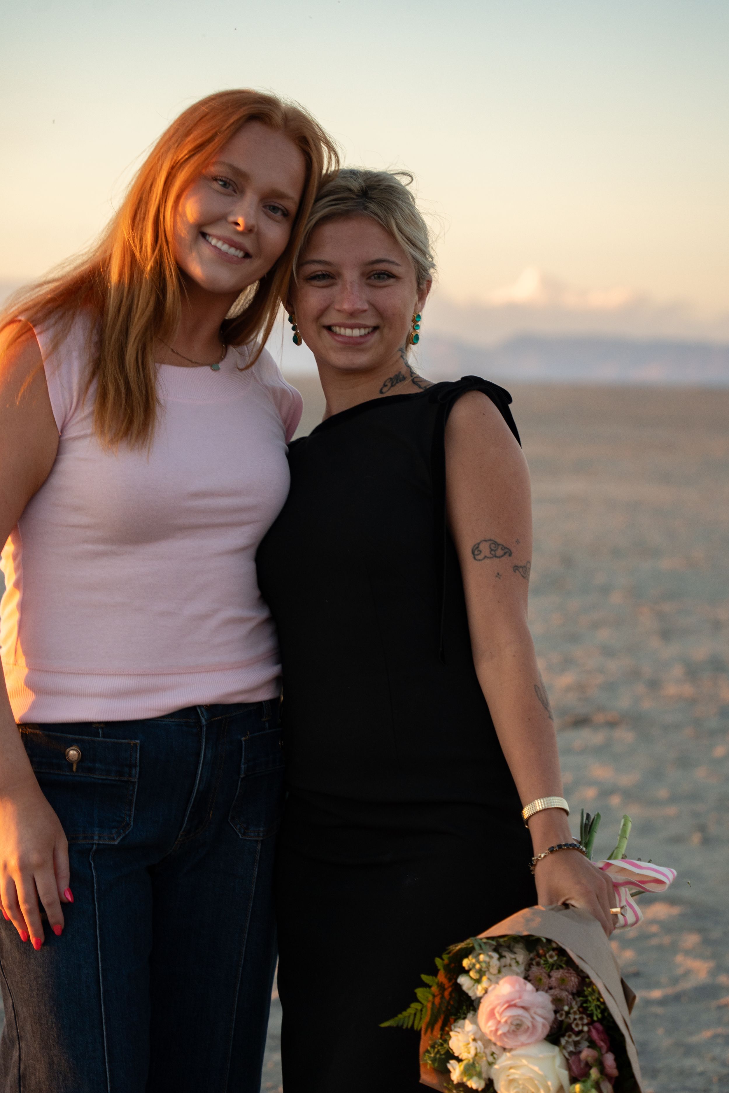 newly engaged girl hugging her best friend in celebration after proposal on salt flats