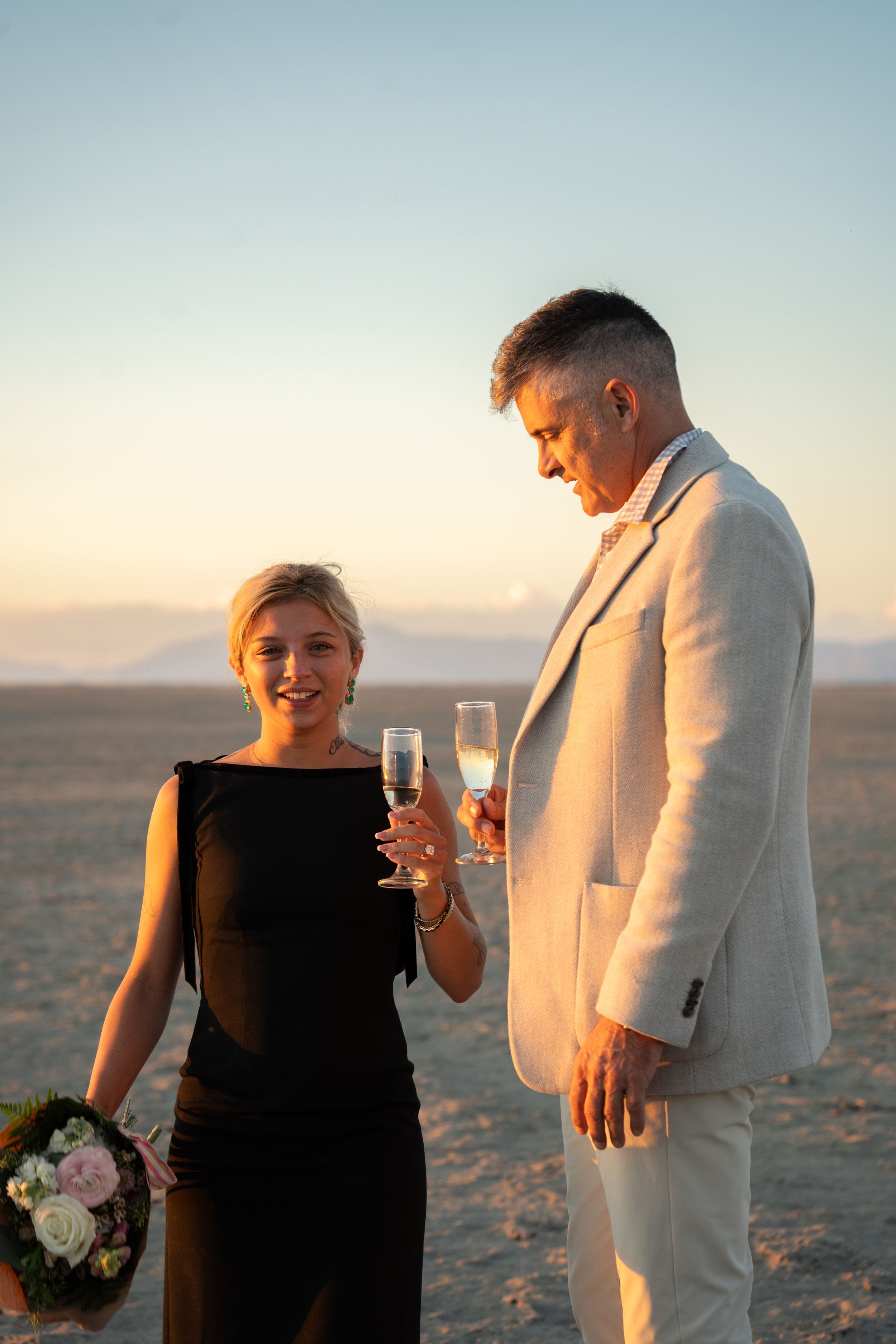 couple holding champagne glasses, preparing for a toast at the great saltair
