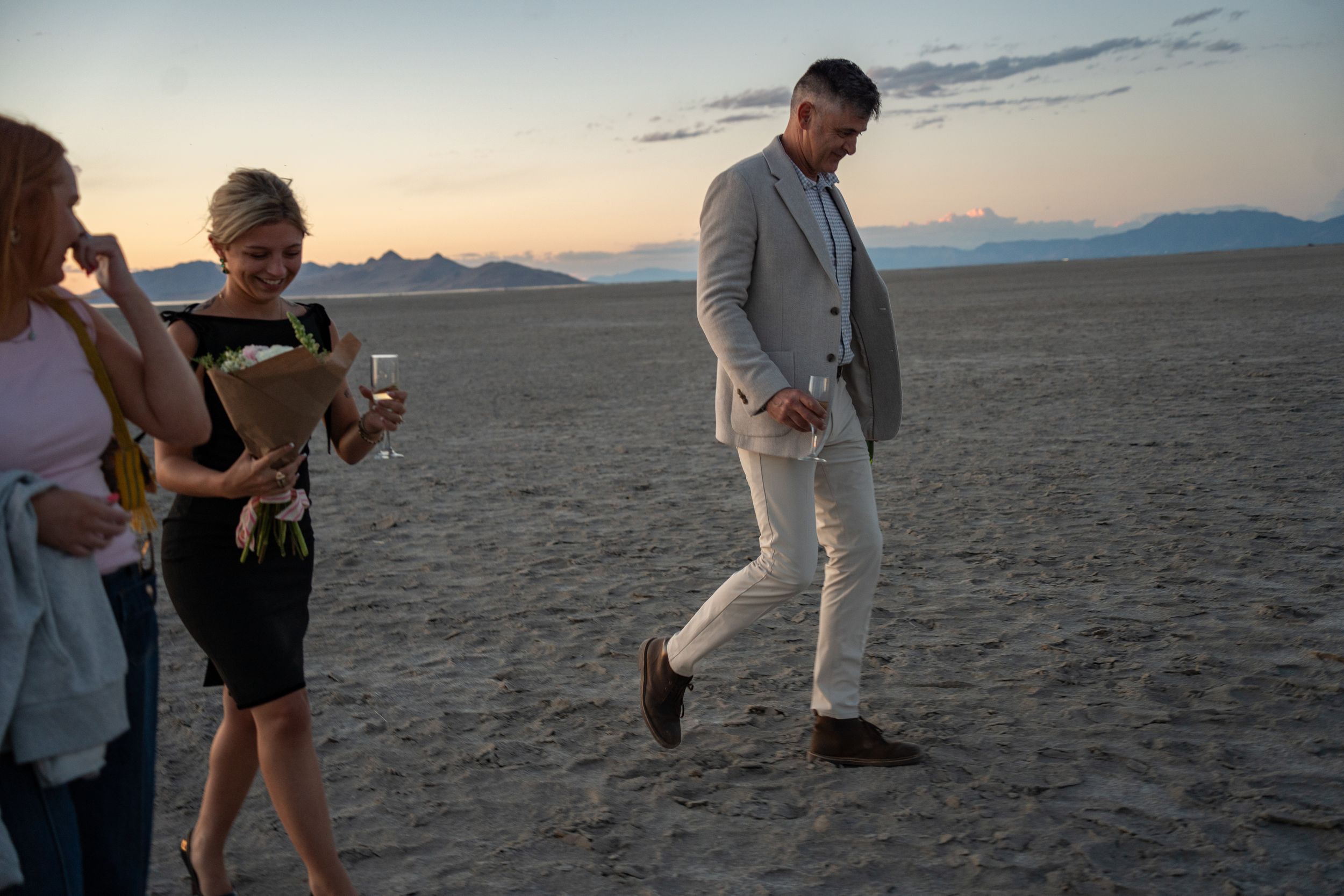 couple walking across the salt flats after a surprise proposal at great saltair
