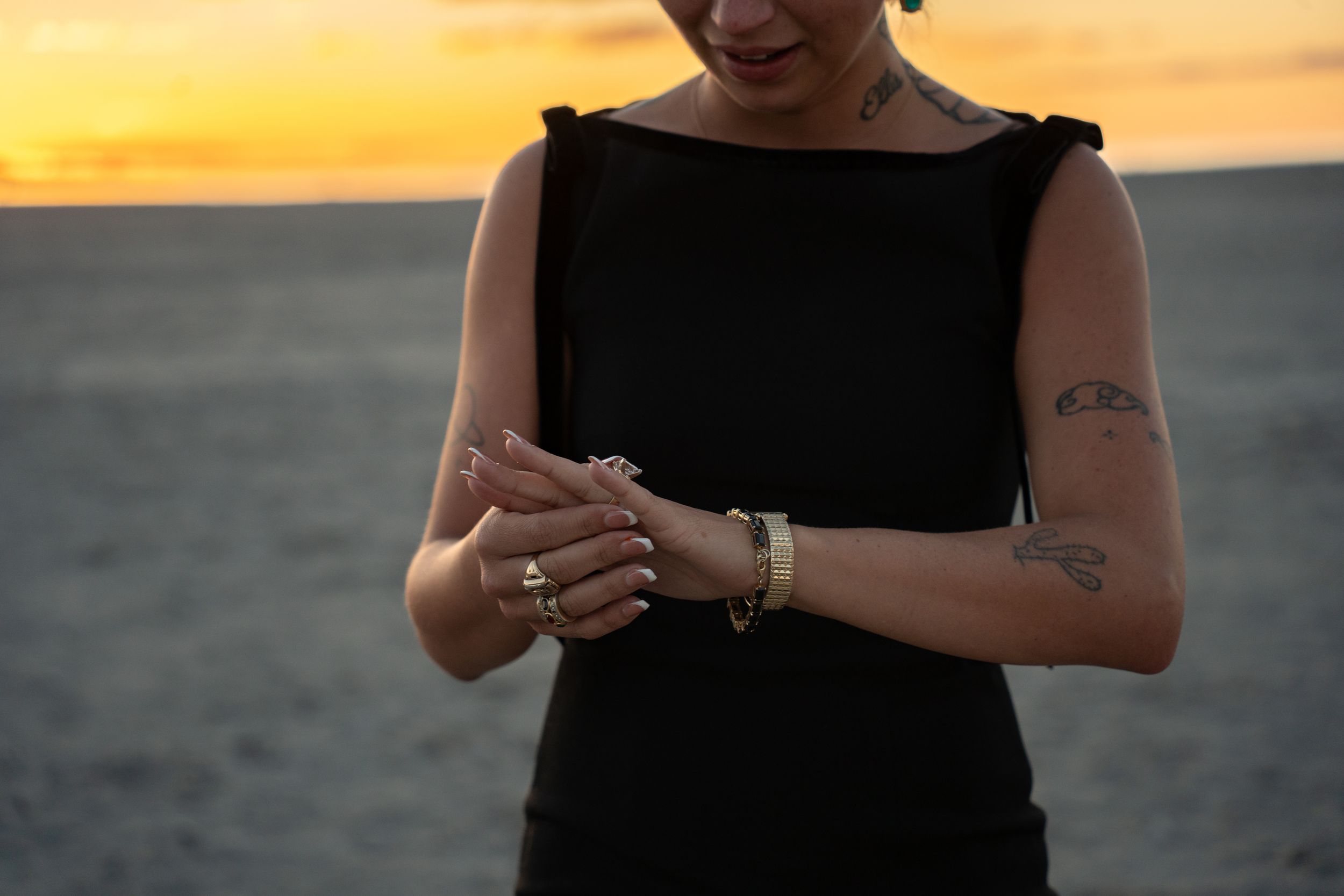 girl admiring engagement ring on her finger with salt flats and sunset in the background