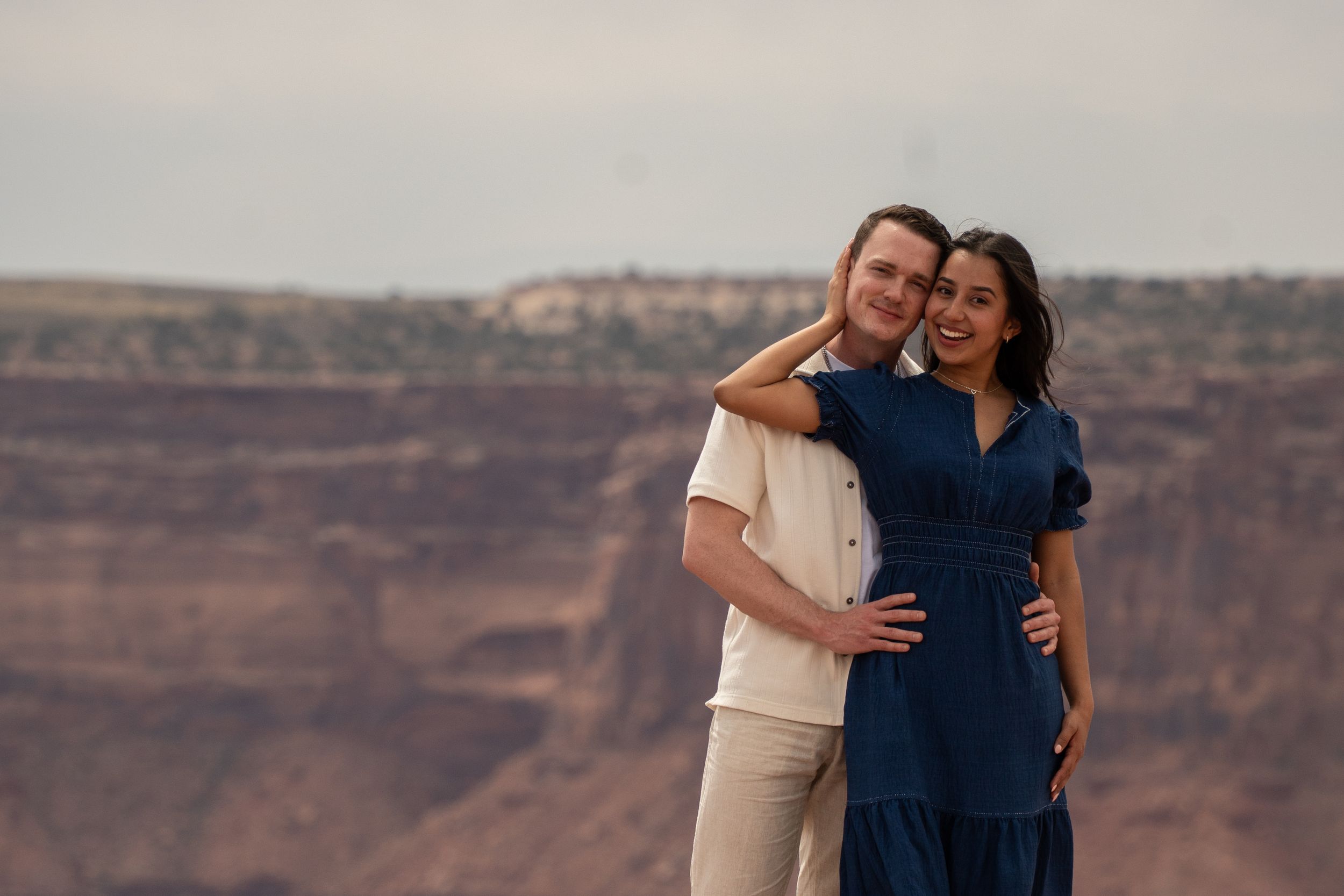 Close-up portrait of a couple embracing at a Dead Horse Point canyon overlook, overlooking Canyonlands National Park
