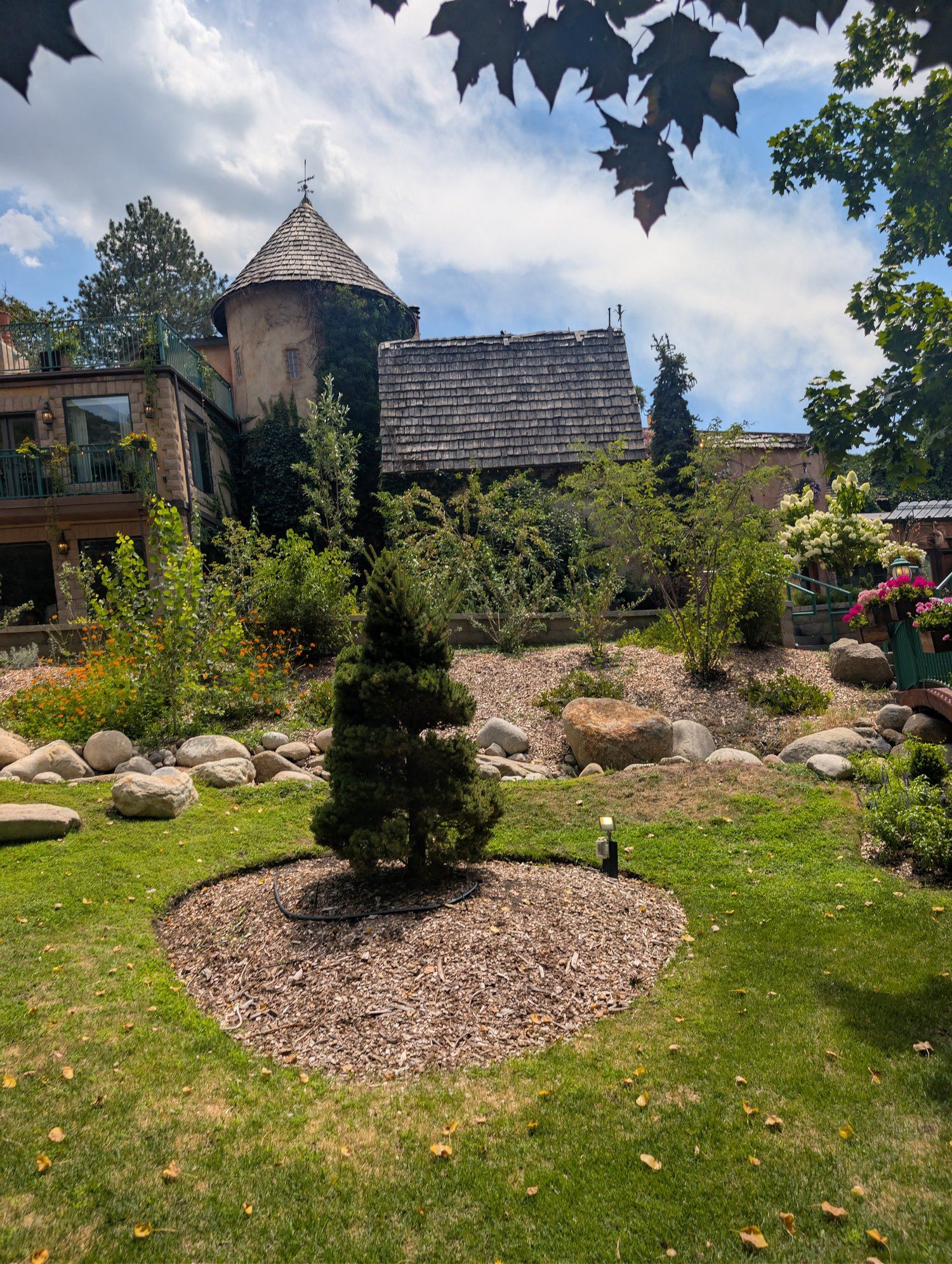 La Caille's stone building with a round turret roof, viewed across the upper lawn
