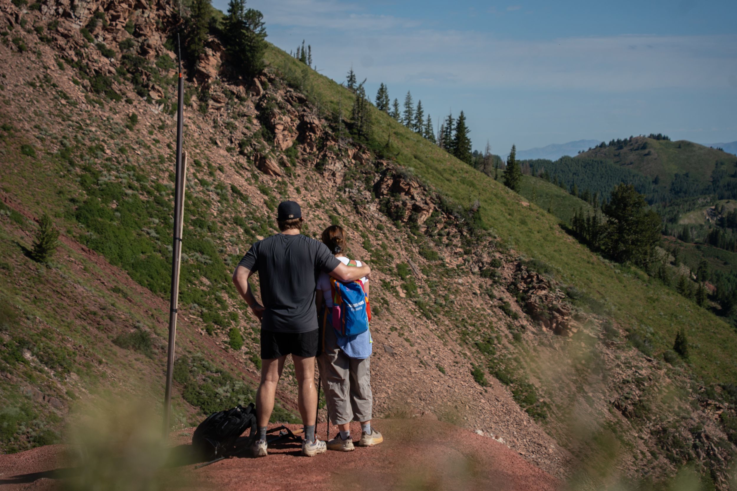 Couple standing arm in arm looking out over a mountain ridge near Park City, Utah
