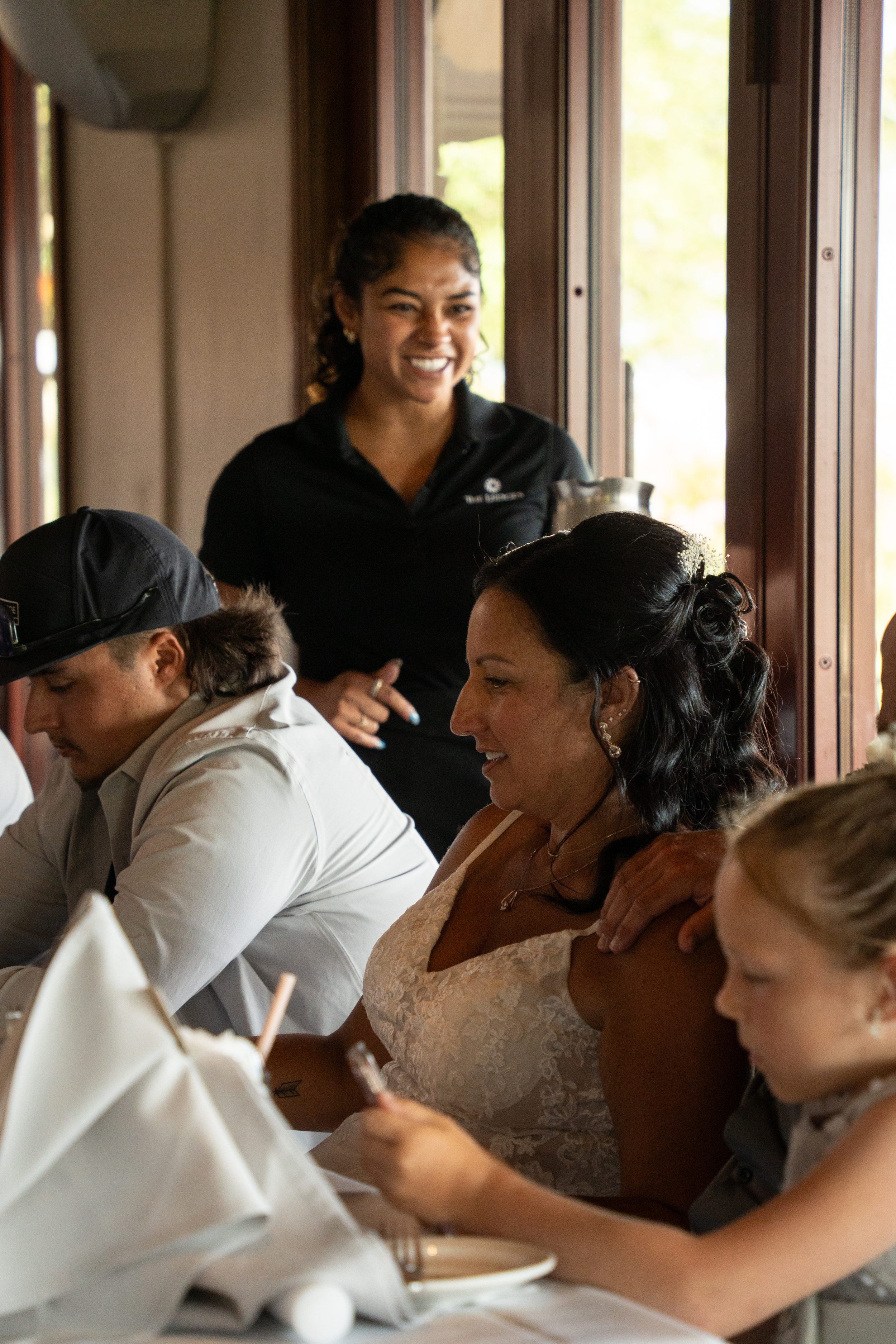Bride laughing with family at the dinner table during the reception at The Ledges clubhouse.