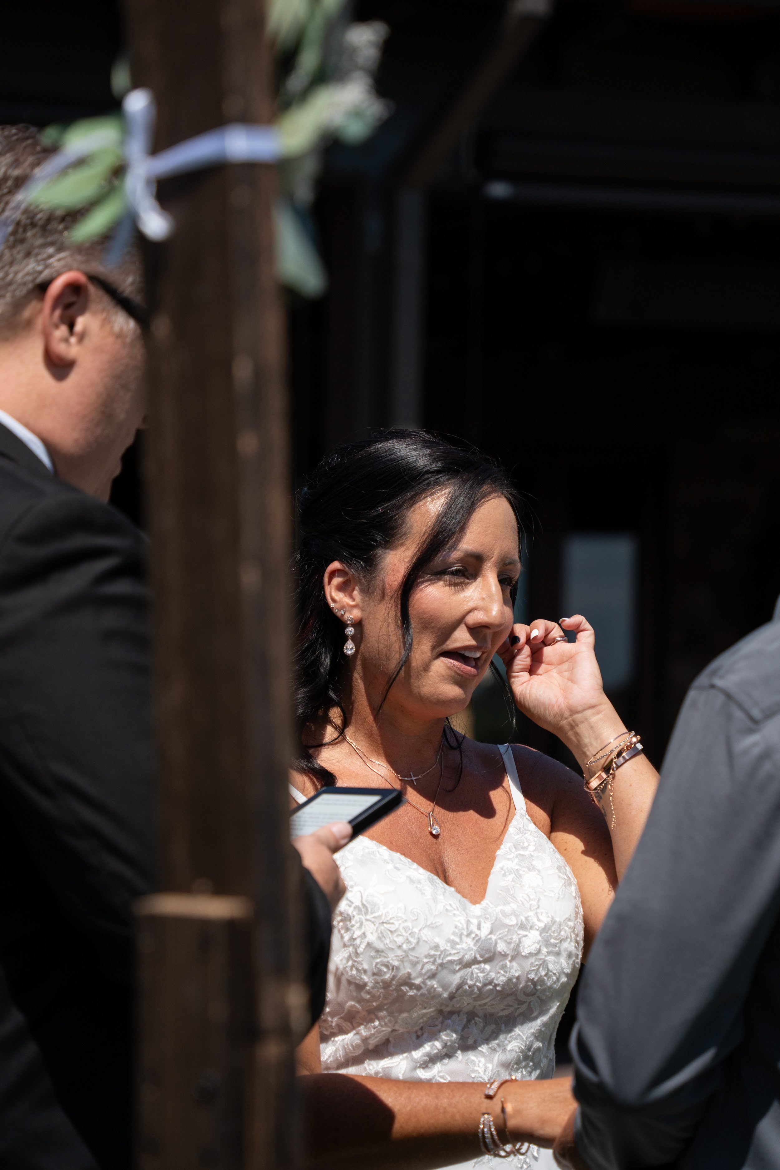 Bride wiping away a tear during an emotional moment in her wedding vows.