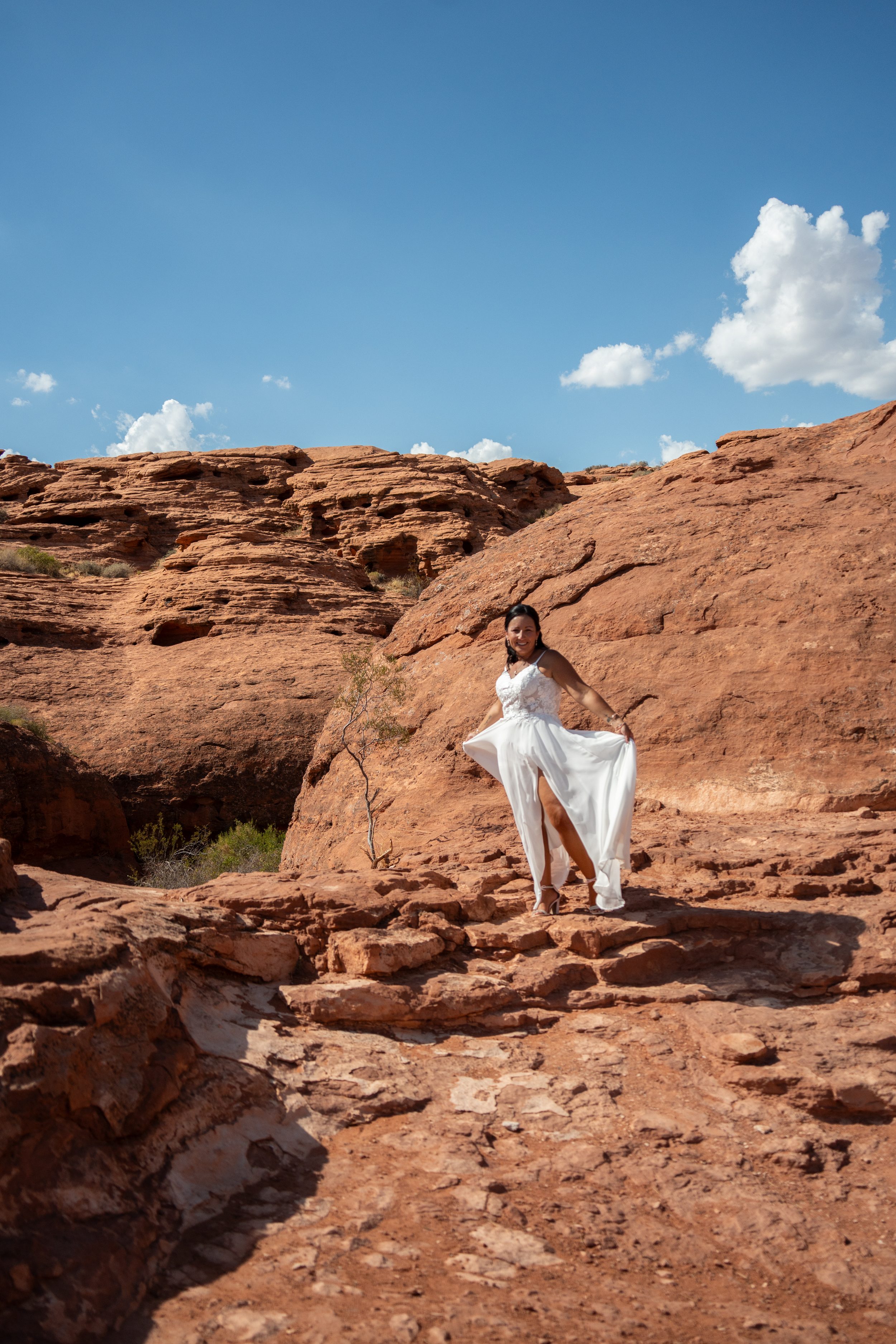 Bride twirling her dress on red rock at Pioneer Park in St. George, Utah.