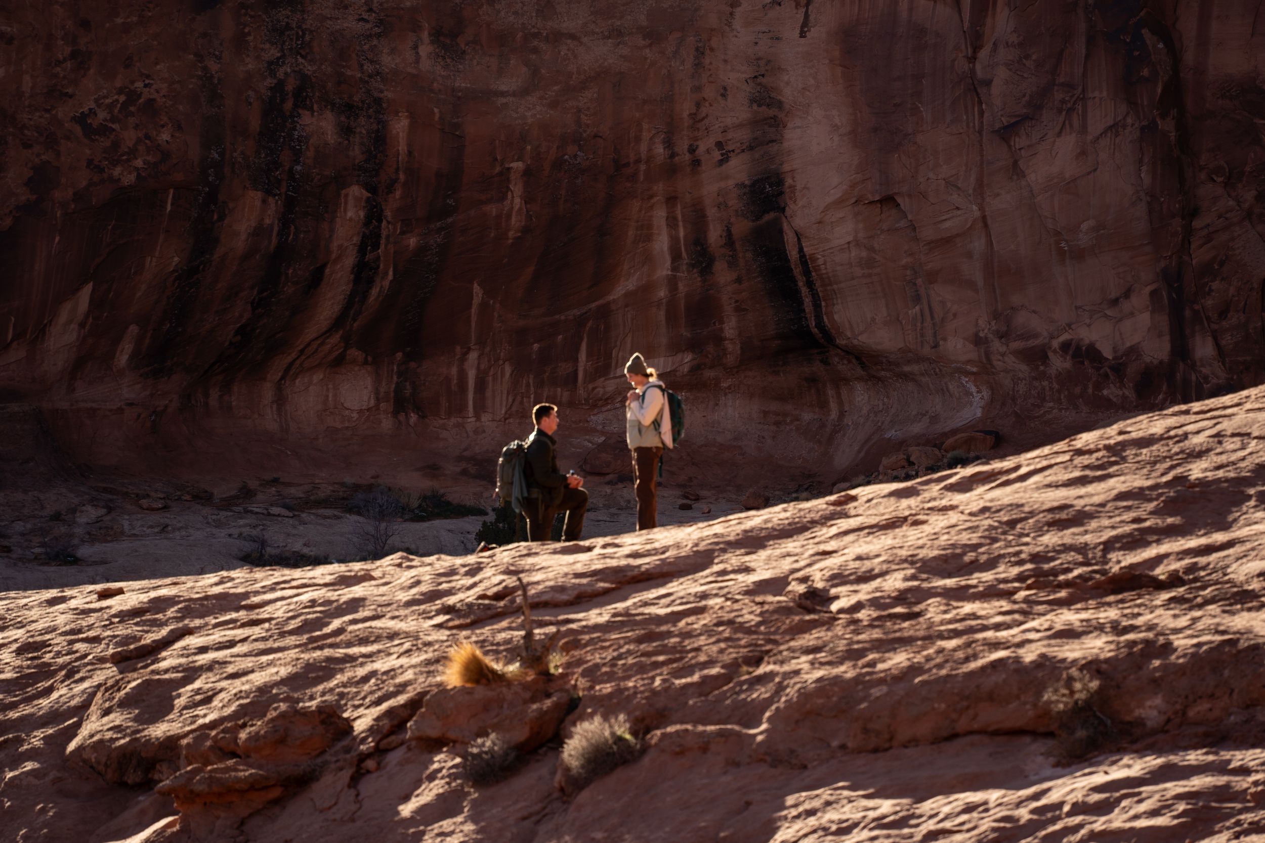 Proposal under a stunning red rock canyon landscape under warm sunlight in a desert wilderness area, Moab, Utah