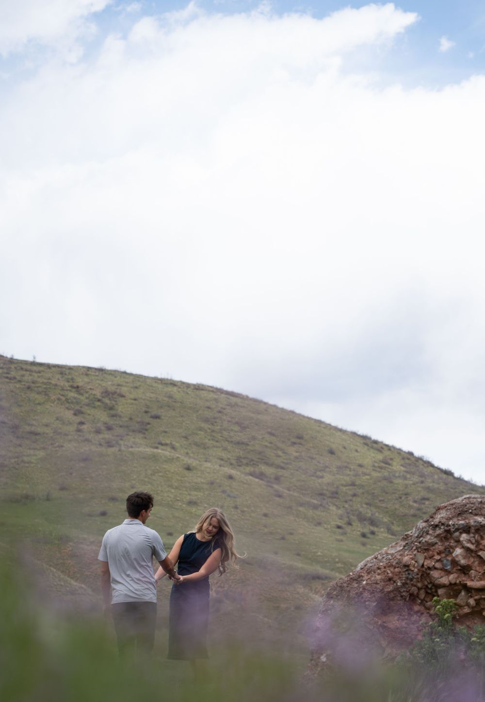 Newly engaged couple dancing in a field of wildflowers in Springville Canyon