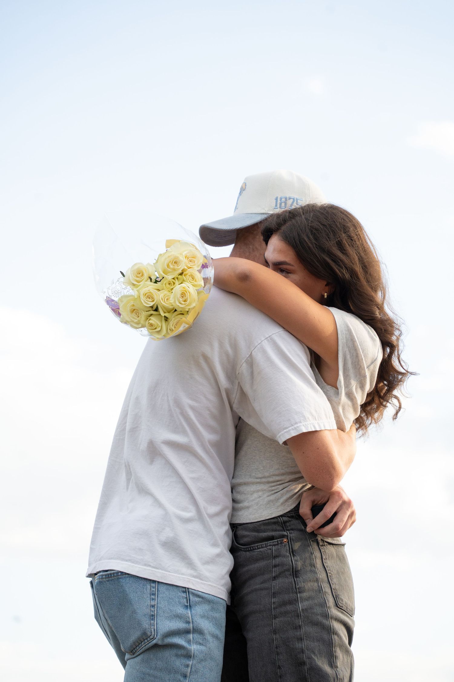 couple hugging after saying yes to engagement with a bouquet hiking proposal in Lindon Utah