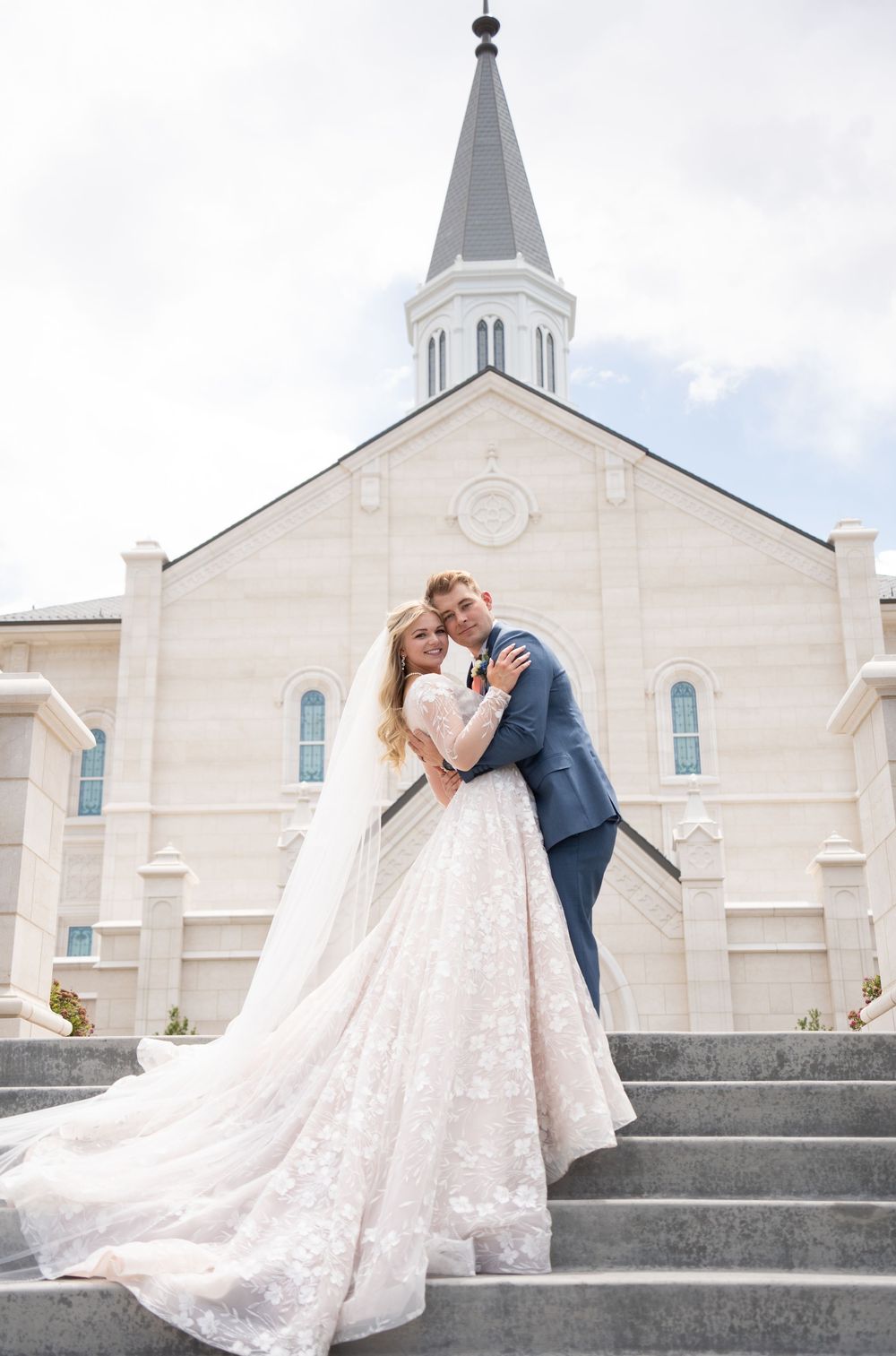 Bride and groom embrace on Taylorsville Temple steps