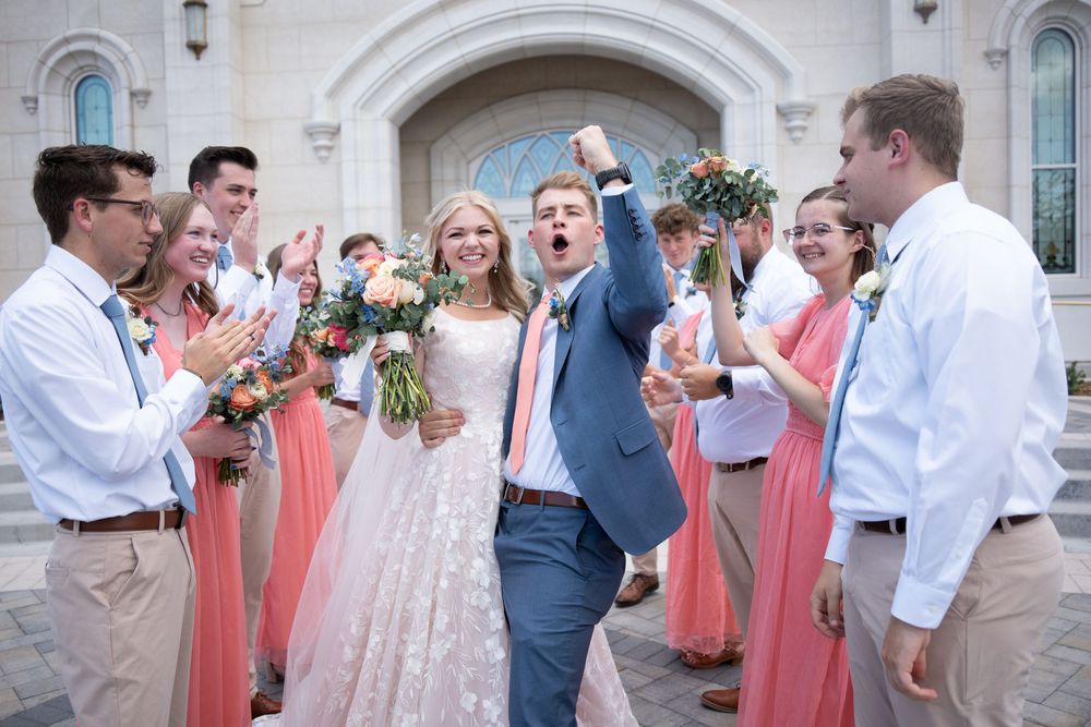 Wedding party in coral and navy blue attire celebrating
