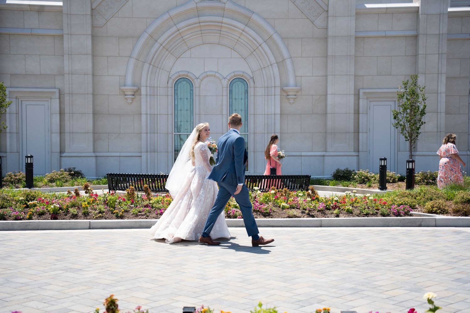 Post temple sealing bride and groom walking around with family