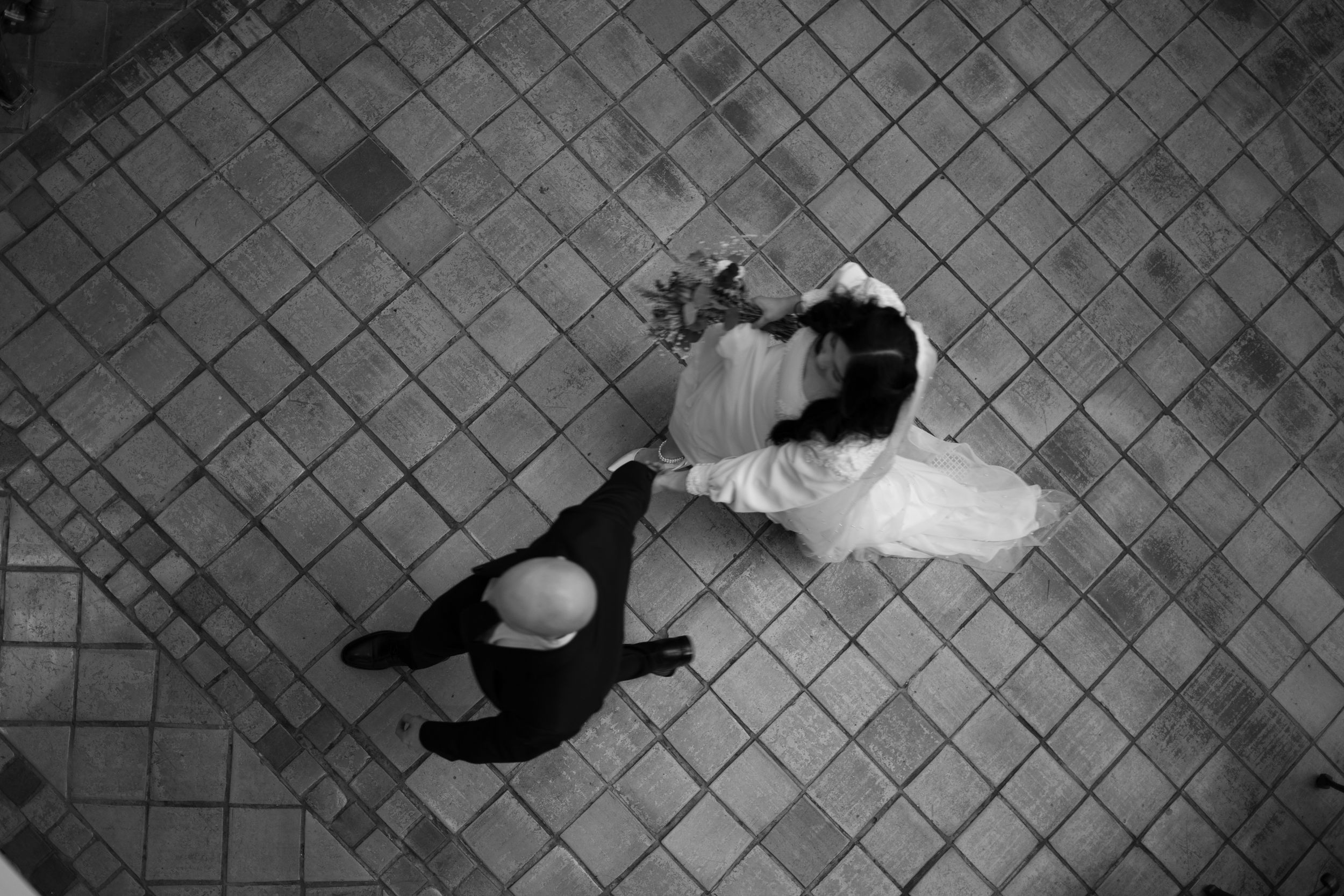 Aerial black and white photo of a bride and groom dancing at their wedding reception