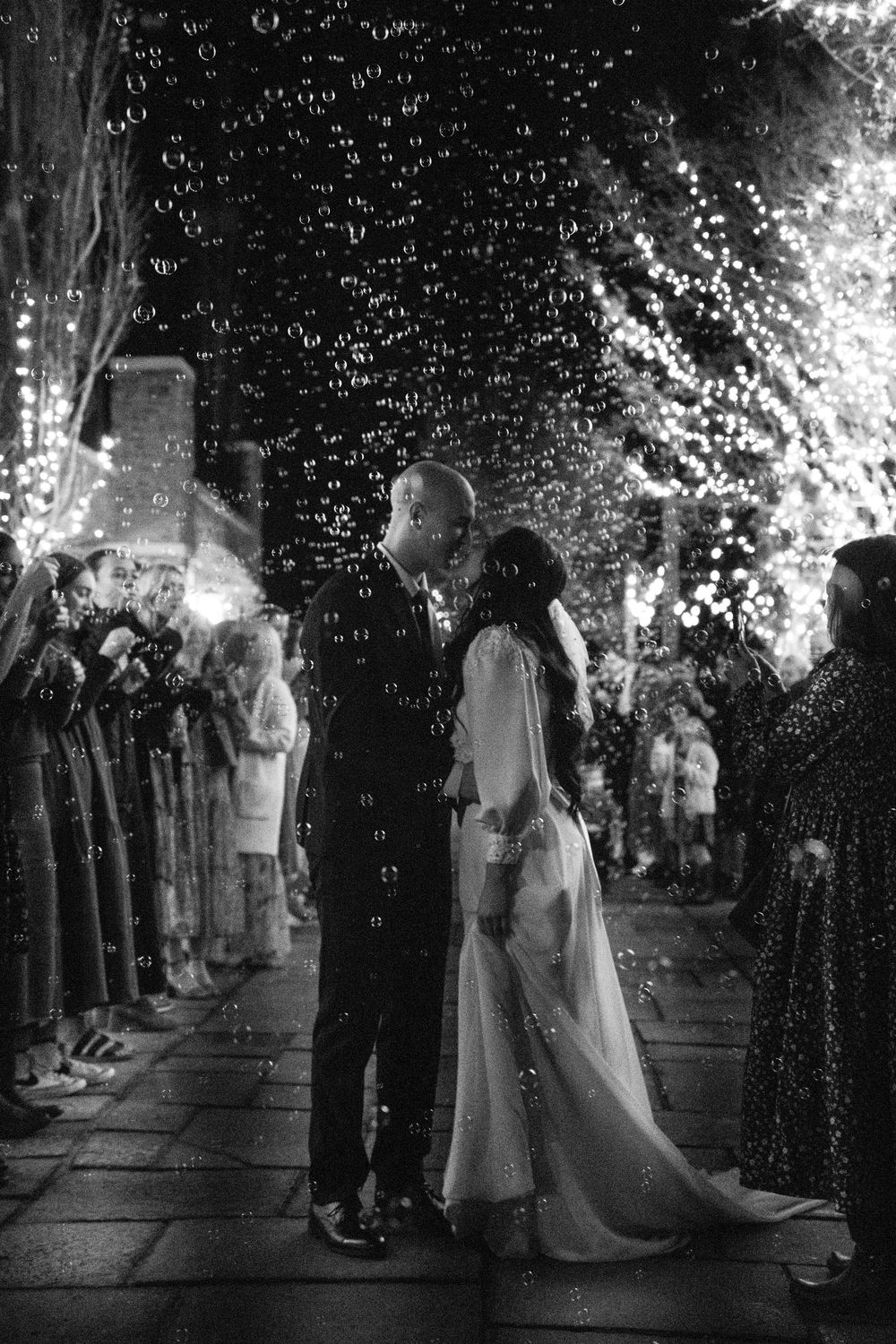Black and white photo of a couple kissing during their wedding