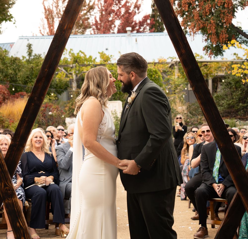 A bride and groom exchange vows during an outdoor Utah autumn ceremony