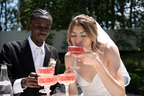 Bride and groom sharing a toast with pink champagne coupes
