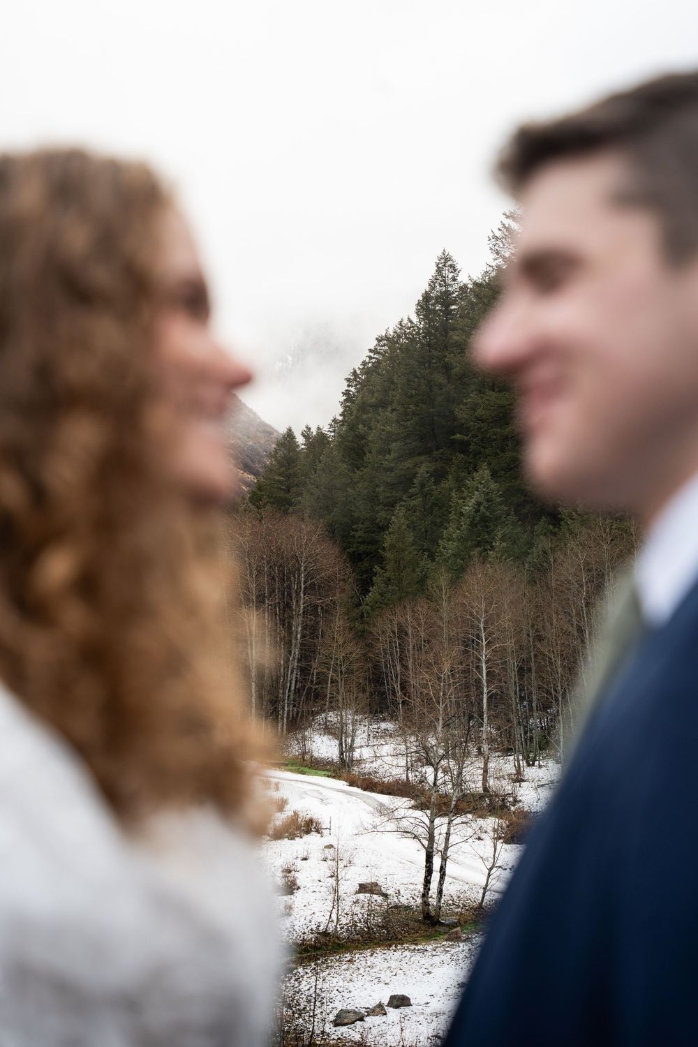 Blurred married couple in wedding attire smiling at each other